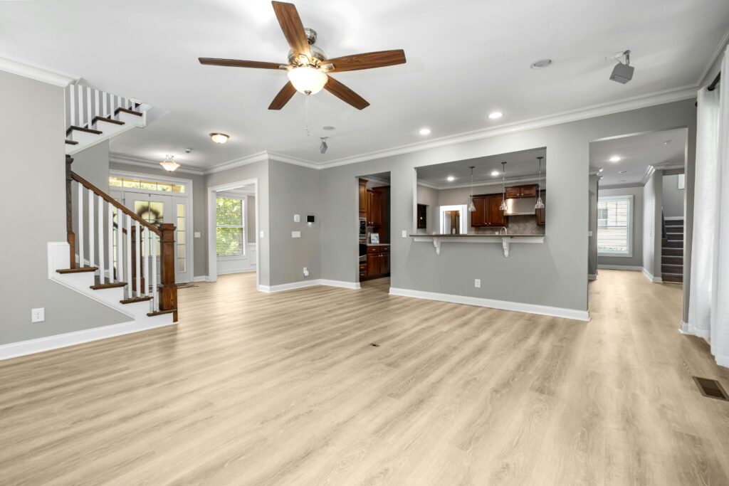 Spacious and modern open-plan living room with wooden flooring and staircase, ideal for home inspiration.